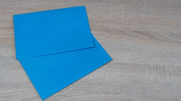 Κοντινό Πλάνο Των Δύο Μπλε Χαρτιών Στο Ξύλινο Τραπέζι — Φωτογραφία Αρχείου