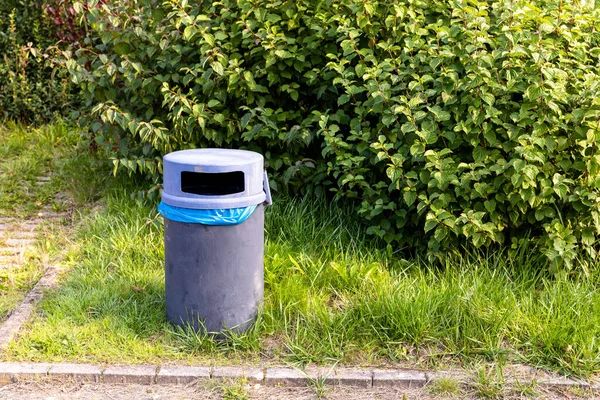 Ein Mülleimer Auf Dem Rasen Gegen Grüne Büsche — Stockfoto