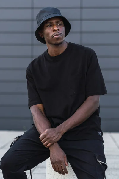 Vertical Shot Young Black Man Street Style Clothes Sitting Pillar — ストック写真