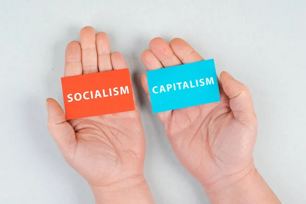 Words Socialism Capitalism Standing Piece Papers Hands Holding Message Political —  Fotos de Stock