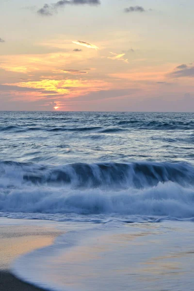 Een Verticaal Shot Van Een Golvende Zee Onder Een Zonsondergang — Stockfoto