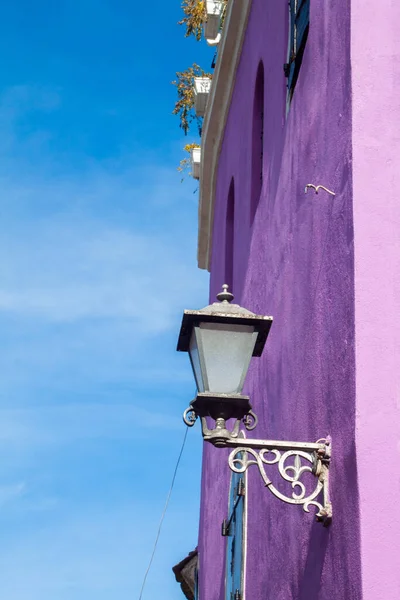 A lamp outside the purple building wall