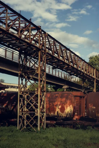 曇り空の金属橋の下で液体貨物を輸送するための錆びた列車の美しい景色 — ストック写真
