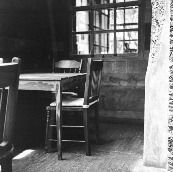 陈旧不堪的老房子里一张简陋的桌子和椅子的灰白比例 — 图库照片