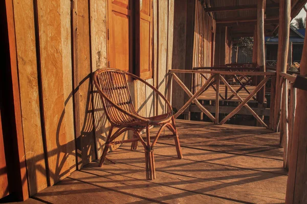 夕阳西下的木制门廊外的藤椅 — 图库照片