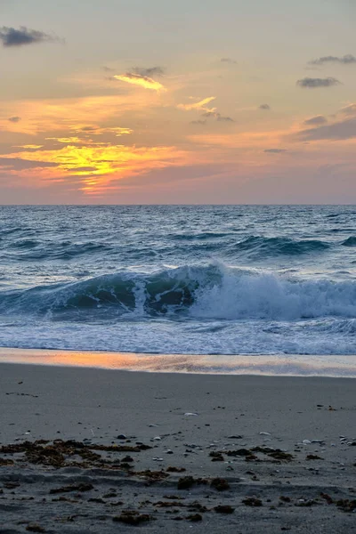 Een Verticaal Shot Van Een Golvende Zee Onder Een Zonsondergang — Stockfoto