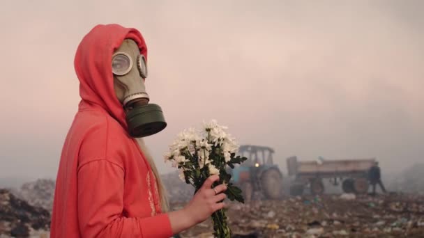 Metraje Una Chica Máscara Gas Con Flores Fondo Del Vertedero — Vídeo de stock