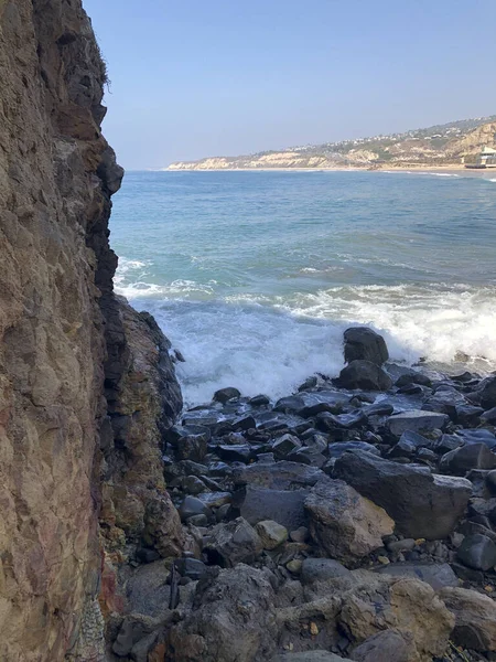 Vertical Shot Beautiful Beach Water Hitting Big Rocks Shore — Φωτογραφία Αρχείου