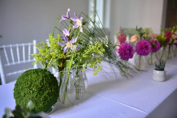 Olika Färgglada Blommorna Små Transparenta Vaser Bordet Med Vit Duk — Stockfoto