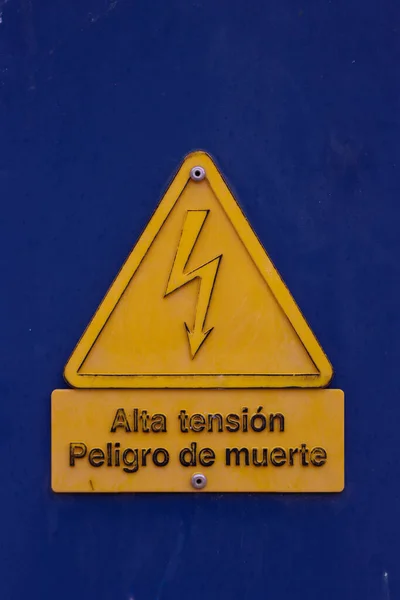 High Voltage Sign Blue Background Sign Spanish — Stok fotoğraf