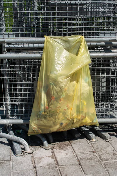 Una Bolsa Basura Plástico Una Valla Metálica Calle — Foto de Stock