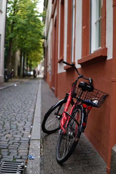 一辆黑色篮子的自行车靠在有白色窗户的棕色建筑物上的近身特写 — 图库照片