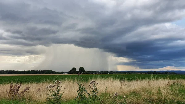 一场夏天的倾盆大雨正在田野上空形成 — 图库照片
