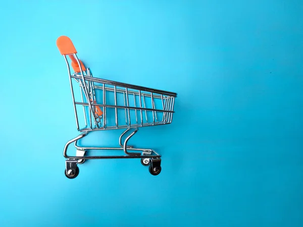 青い背景に隔離されたショッピングトロリーのクローズアップ ショッピングとビジネスのコンセプト — ストック写真