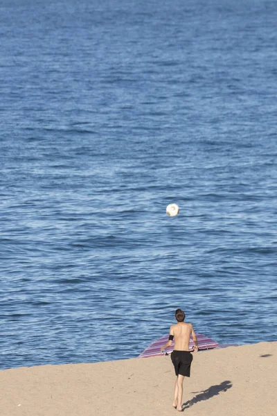 一个在海滩上打排球的年轻人 — 图库照片