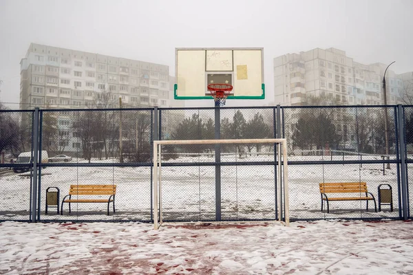 Una Bella Vista Innevata Campo Basket Edifici Sullo Sfondo Nebbioso — Foto Stock