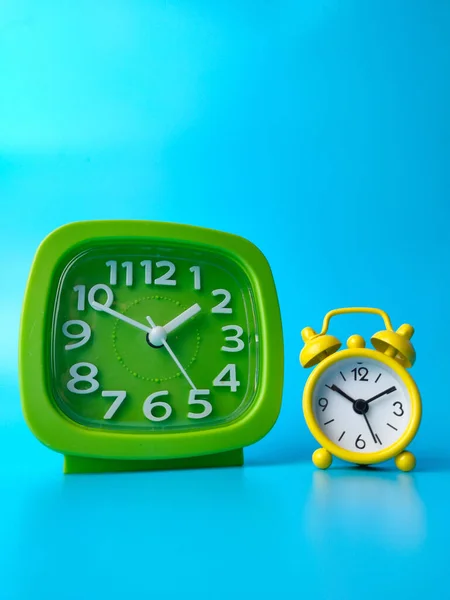 Mavi Bir Zemin Üzerinde Izole Edilmiş Yeşil Sarı Alarm Saatlerinin — Stok fotoğraf