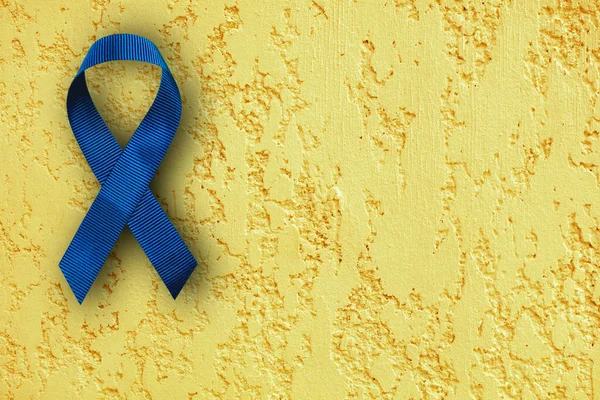 Ein Blaues Band Zur Krebsvorbeugung Isoliert Auf Gelbem Hintergrund Mit — Stockfoto