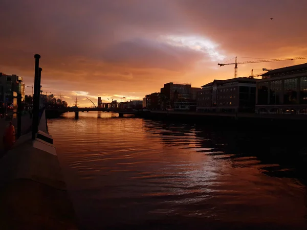 ダブリン アイルランド 12月04 2019 ダブリンのリフィー川の上の日の出にある建物とオレンジの空のシルエット ダブリン港への眺め — ストック写真