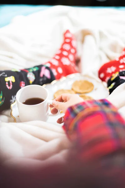 Vertical Shot Person Cozy Christmas Pajamas Socks Drinking Tea Eating — стоковое фото