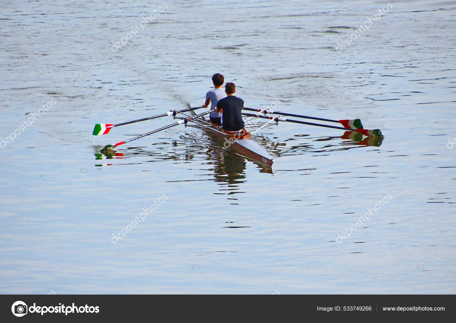 Landscape View Two Rowers Paddling Beautiful Lake Stock Photo by
