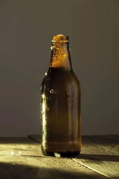 Eine Vertikale Aufnahme Einer Bierflasche Auf Einer Holzoberfläche — Stockfoto