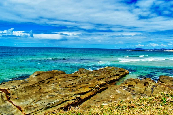 蓝天下的岛屿上的一个岩石海滩 — 图库照片