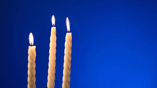 Drei Brennende Kerzen Isoliert Auf Blauem Hintergrund — Stockfoto