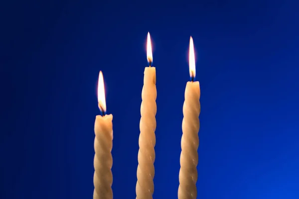 Три Запалені Свічки Ізольовані Синьому Фоні — стокове фото