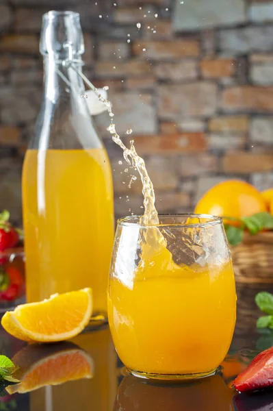 Leckeres Spritzendes Orangengetränk Mit Früchten Und Saftflasche Hintergrund — Stockfoto