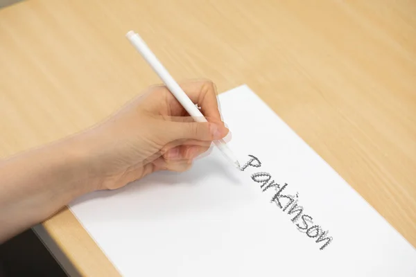 Woman Parkinsons Disease Trying Write White Paper Tremors — Stock Photo, Image