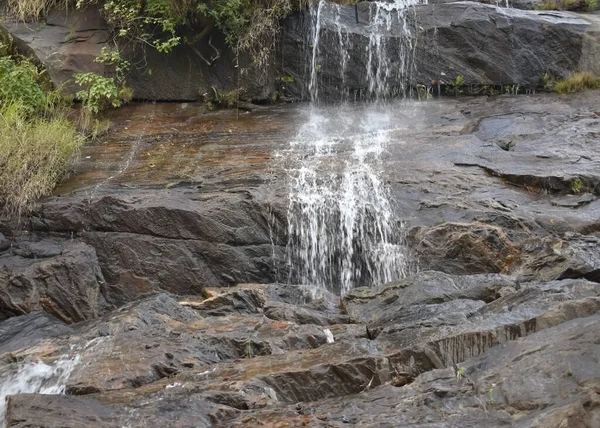 印度岩石悬崖上一个小瀑布的选择性聚焦图 — 图库照片