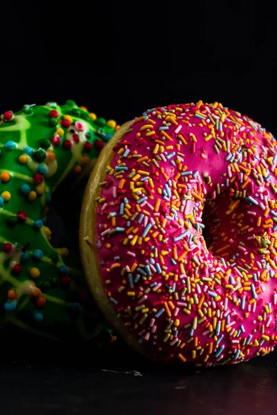Glazed Donuts Topped Colorful Sprinkles Isolated Black Background — Fotografia de Stock