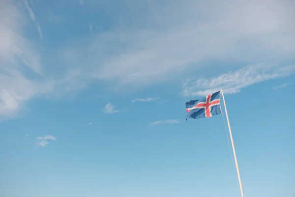 Machająca Flaga Narodowa Islandii Pod Pochmurnym Błękitnym Niebem — Zdjęcie stockowe