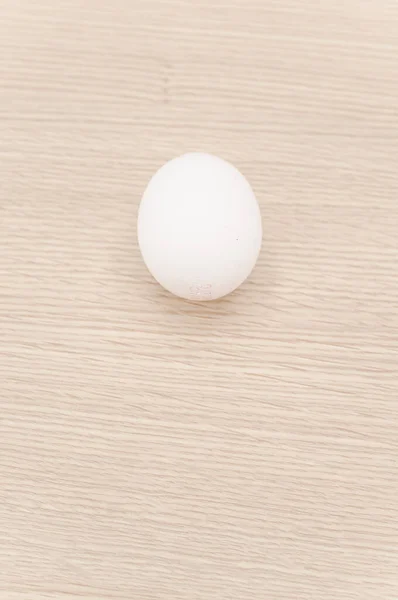 テキストのためのコピースペースを持つ天然の木製の卓上表面上の有機的な白い卵 — ストック写真