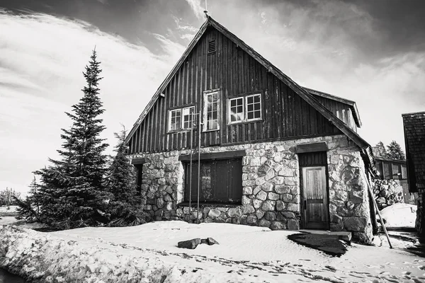 明るい晴れた空の下で山小屋のグレースケール — ストック写真