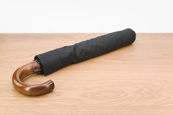 Black Foldable Umbrella Solid Wood Handle Wooden Surface Copy Space — Stok fotoğraf