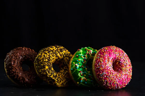 Group Colorful Glazed Donuts Sprinkles Isolated Black Background Copy Space — Stockfoto