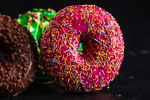 Bunt Glasierte Donuts Mit Streuseln Schwarzen Hintergrund — Stockfoto