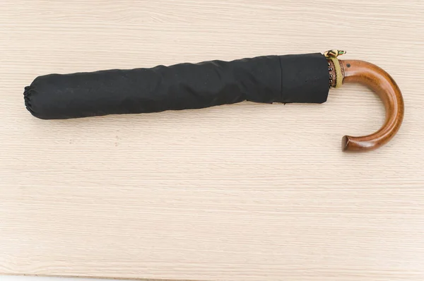 Black Foldable Umbrella Solid Wood Handle Wooden Surface Copy Space — 图库照片