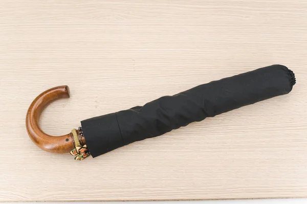 Black Foldable Umbrella Solid Wood Handle Wooden Surface Copy Space — 图库照片