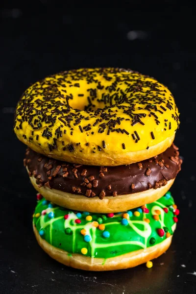 Vertical Shot Stacked Glazed Donuts Sprinkles Isolated Black Background — Stockfoto