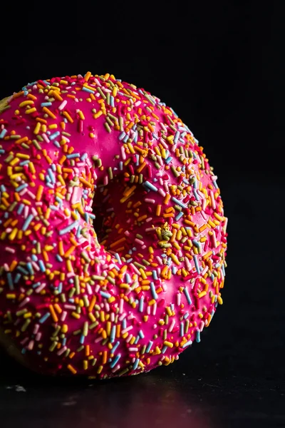 Vertical Shot Pink Glazed Donut Sprinkles Isolated Black Background — Stock Fotó