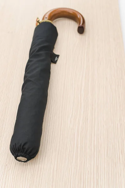 Black Foldable Umbrella Solid Wood Handle Wooden Surface Copy Space — Stock Photo, Image