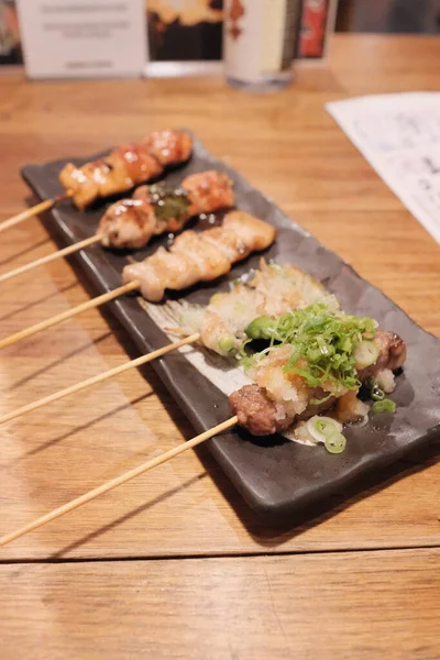 四角形の皿の上に日本の居酒屋の食べ物串のクローズアップショット — ストック写真