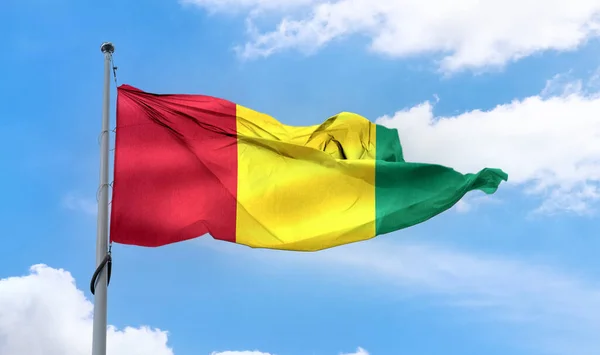 Flaga Gwinei Machająca Słupie Błękitnym Niebie — Zdjęcie stockowe