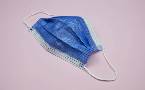 Una Mascarilla Azul Aislada Sobre Fondo Rosa Claro — Foto de Stock