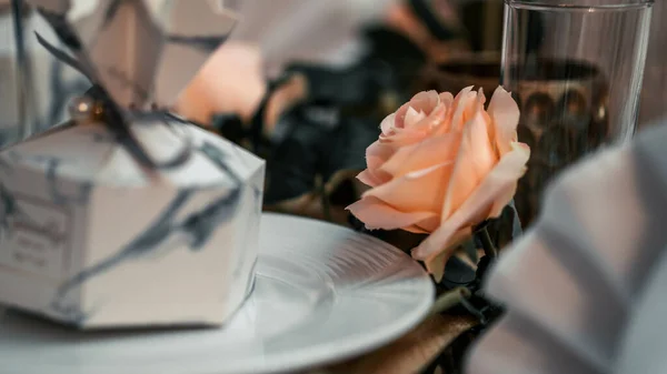 在节庆桌上 有一张精选的粉红色玫瑰的照片 上面有一个包裹着礼物的白色盘子 — 图库照片