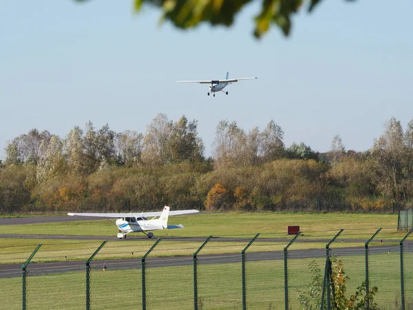 ドイツのエーゲルスバッハ 2021年10月24日 晴れた日にエーゲルスバッハ空港の滑走路に接近中のプロペラ機と待機中の航空機 — ストック写真