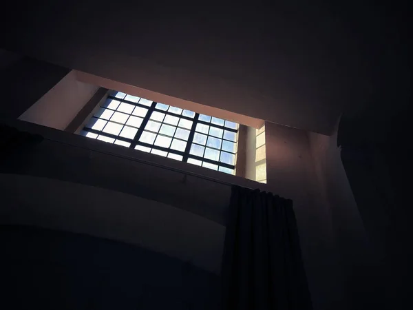 Niskokątne Ujęcie Małego Kwadratowego Okna Kratami Ciemnym Pomieszczeniu — Zdjęcie stockowe